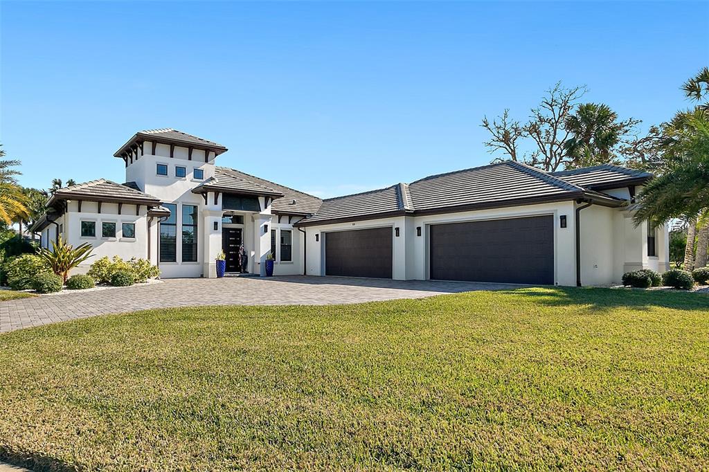 100 Seaside Pt Point Flagler Beach, FL 32136 - Photo 12 of 70 a front view of a house with a yard and garage