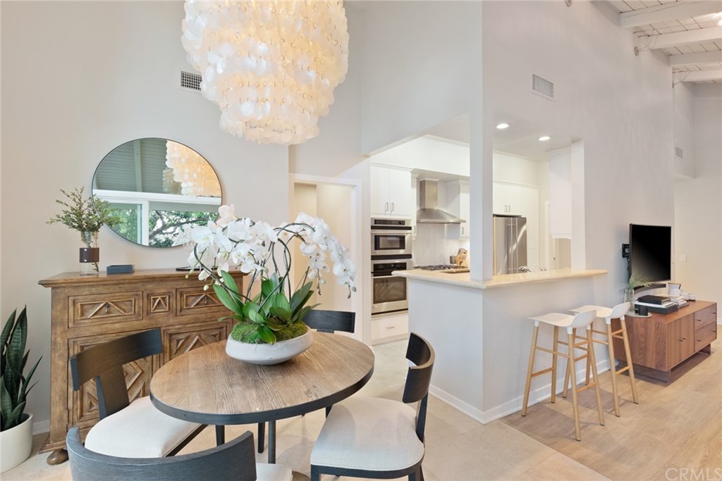 504 Avenida Largo Newport Beach, CA 92660 - Photo 23 of 36 a dining room with furniture a potted plant a fireplace and a chandelier