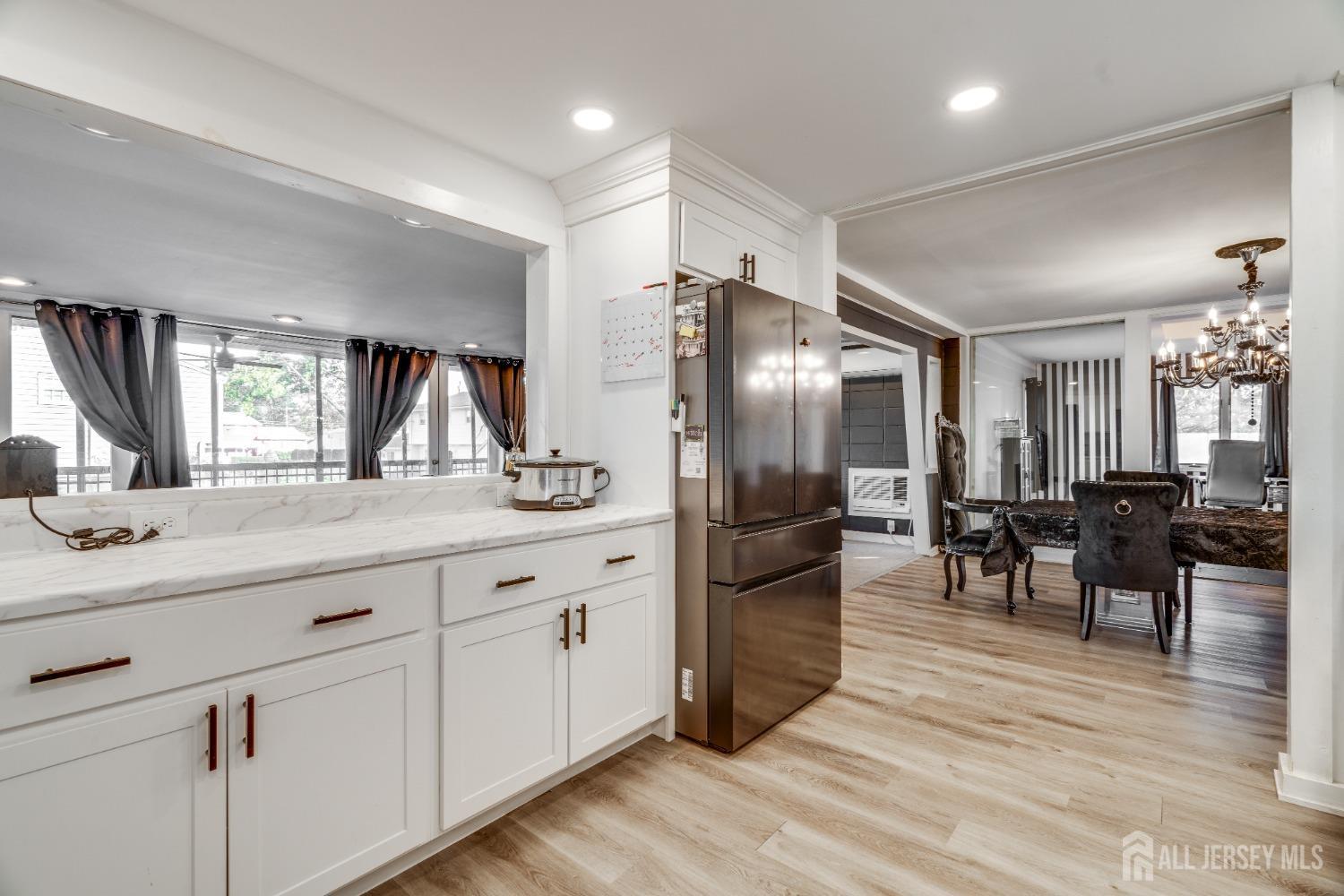 123 Risoli Terrace South Plainfield, NJ 07080 - Photo 30 of 46 a kitchen with stainless steel appliances kitchen island granite countertop a refrigerator a stove a dining table and chairs with wooden floor