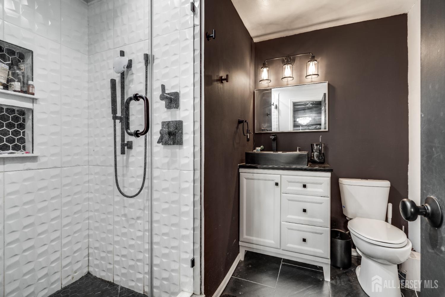 123 Risoli Terrace South Plainfield, NJ 07080 - Photo 42 of 46 a bathroom with a toilet sink vanity and mirror