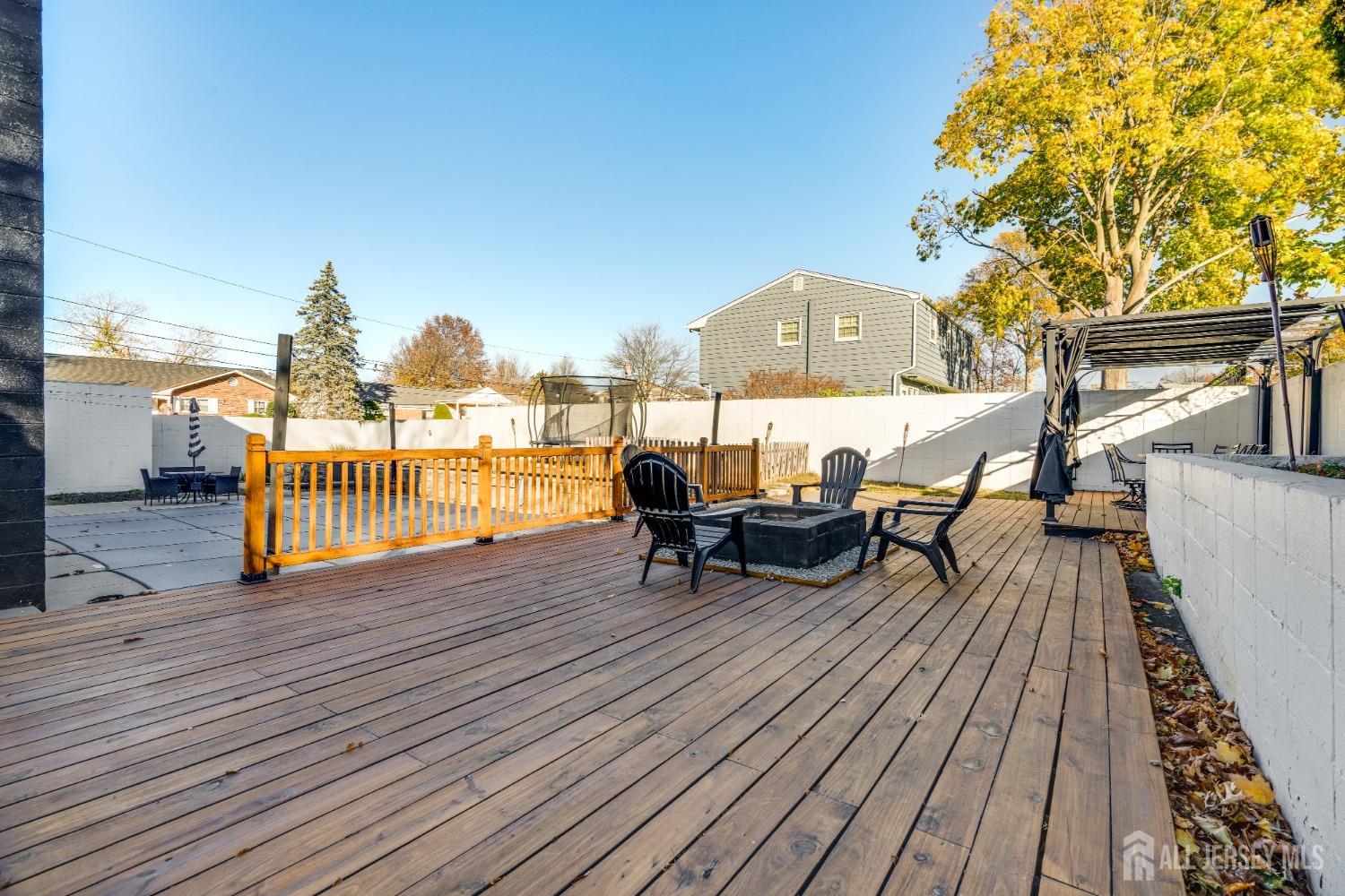 123 Risoli Terrace South Plainfield, NJ 07080 - Photo 10 of 46 a view of a roof deck with table and chairs wooden floor and fence