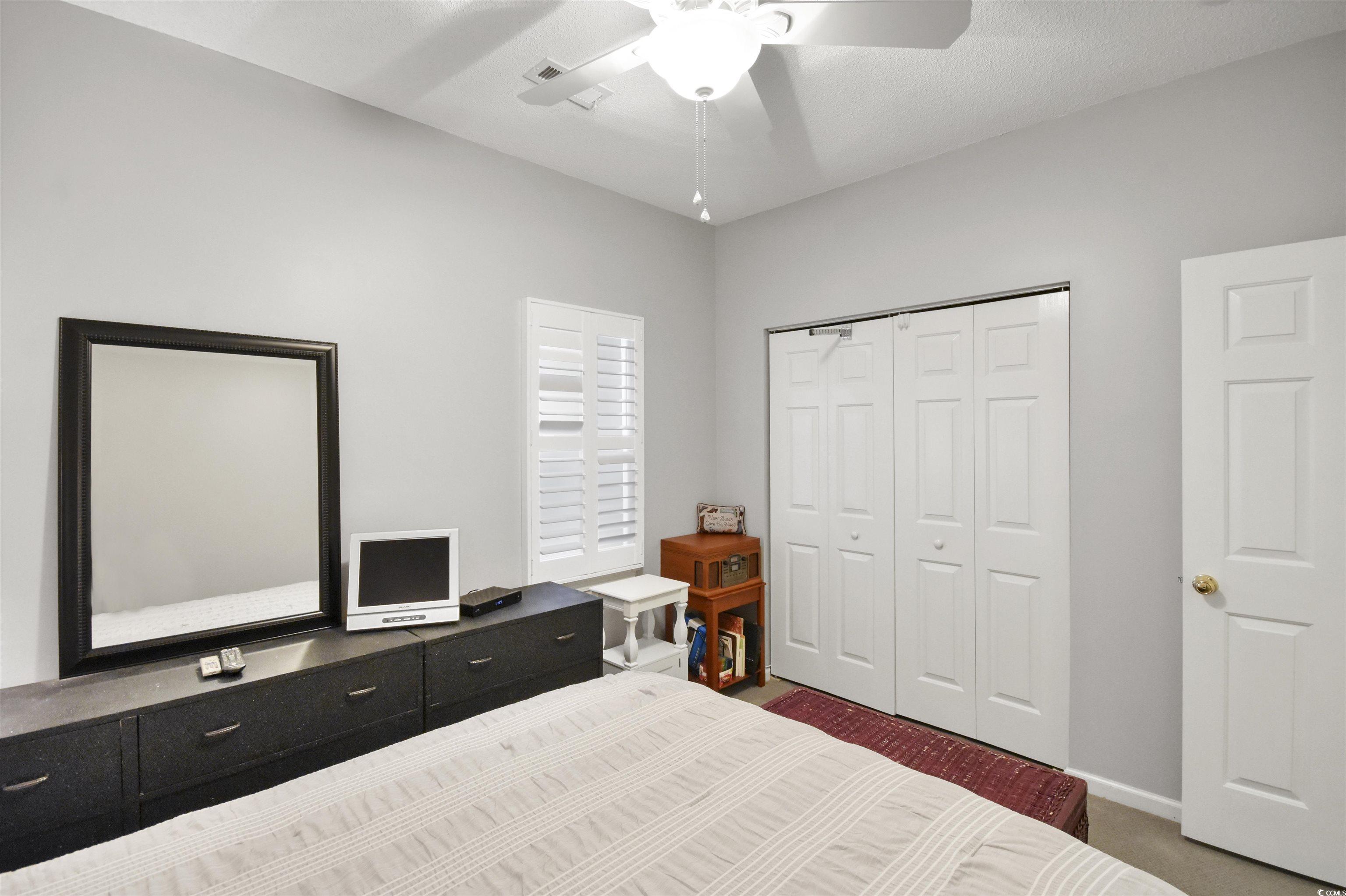 4502 Sweetwater Boulevard, Unit 4502 Murrells Inlet, SC 29576 - Photo 11 of 28 Bedroom featuring ceiling fan, dark carpet, and a closet