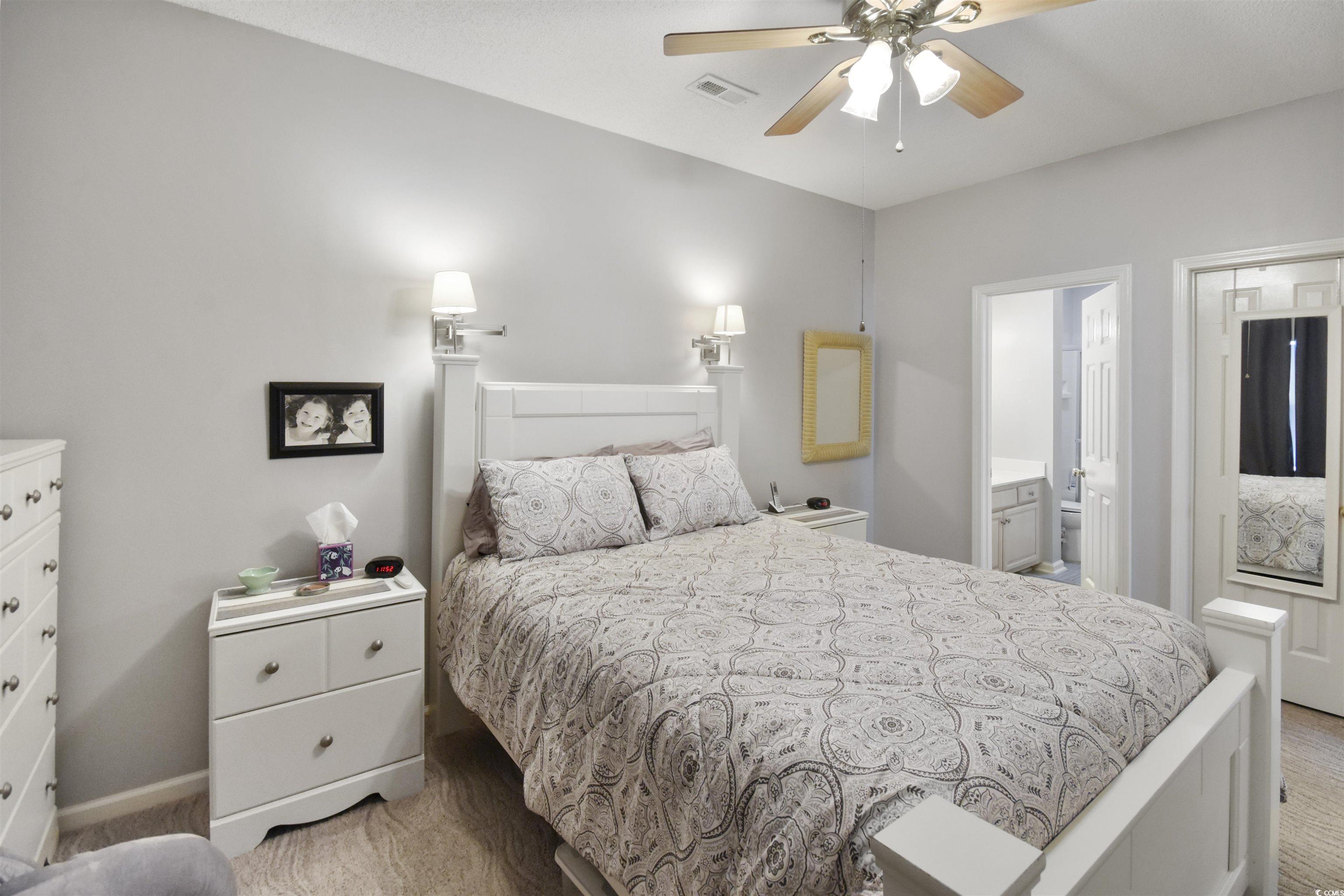 4502 Sweetwater Boulevard, Unit 4502 Murrells Inlet, SC 29576 - Photo 16 of 28 Bedroom featuring light colored carpet, a ceiling fan, and ensuite bathroom