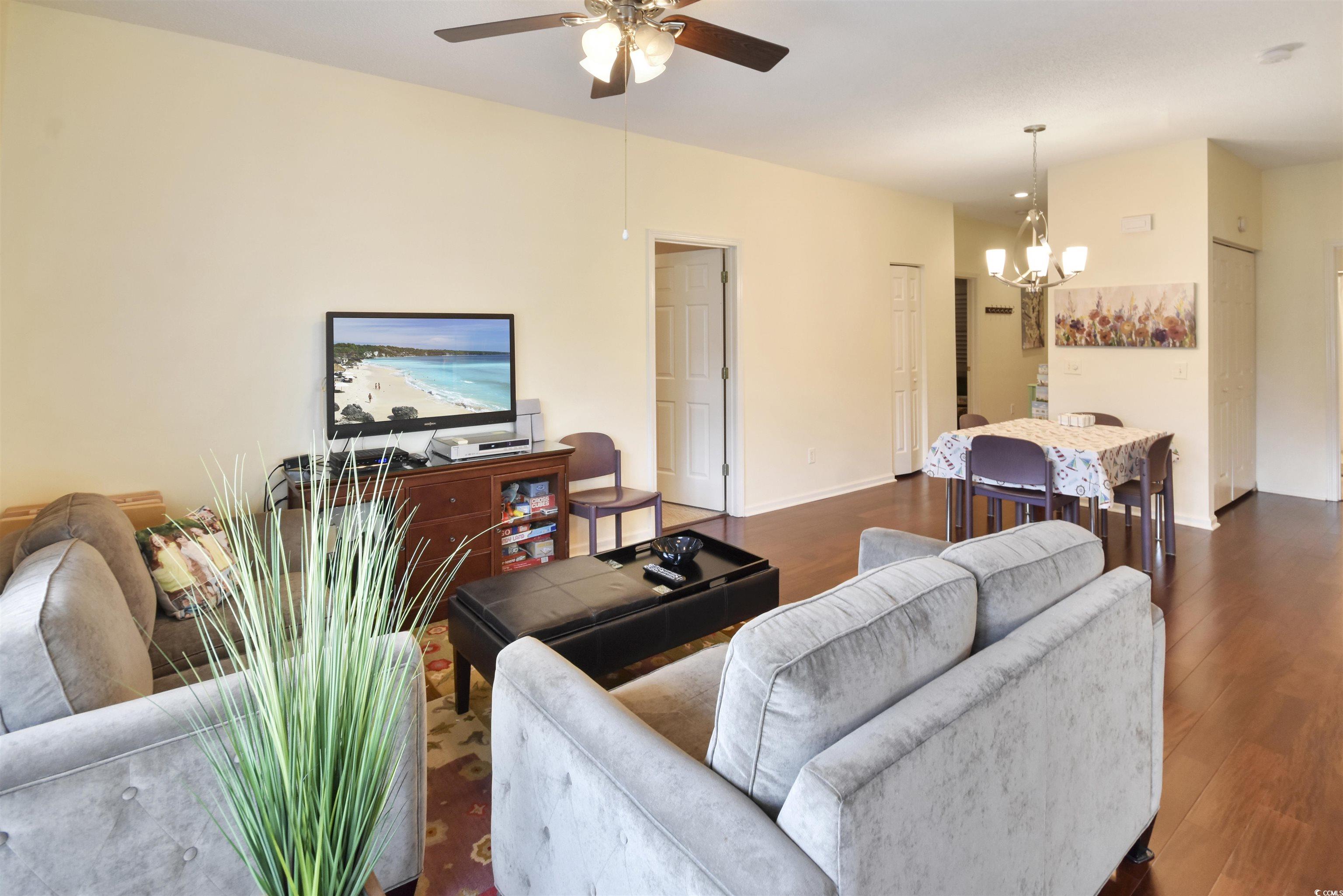 4502 Sweetwater Boulevard, Unit 4502 Murrells Inlet, SC 29576 - Photo 2 of 28 Living area featuring wood finished floors, a chandelier, and a ceiling fan
