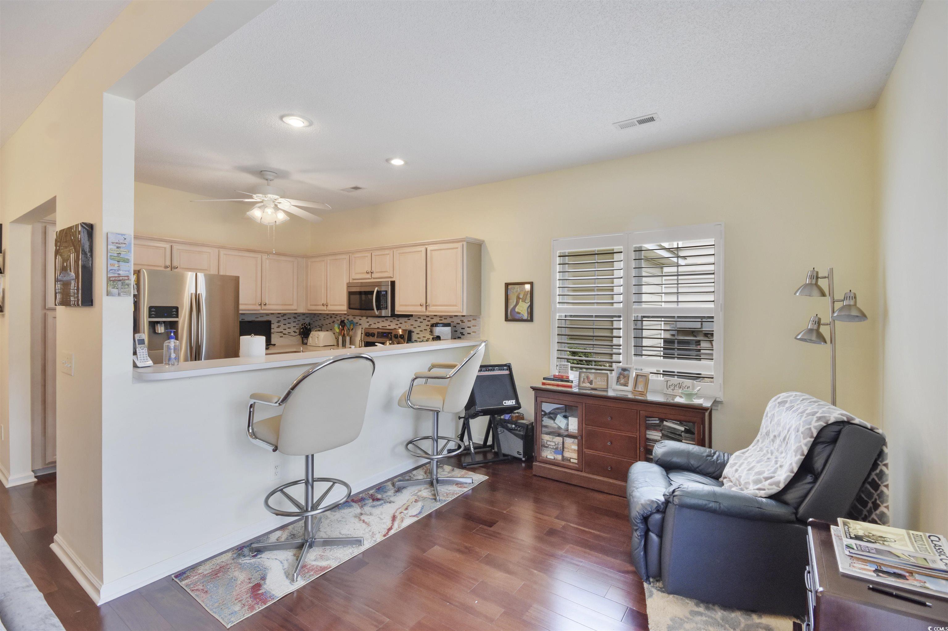 4502 Sweetwater Boulevard, Unit 4502 Murrells Inlet, SC 29576 - Photo 4 of 28 Kitchen with appliances with stainless steel finishes, tasteful backsplash, dark wood-style flooring, a kitchen bar, and recessed lighting