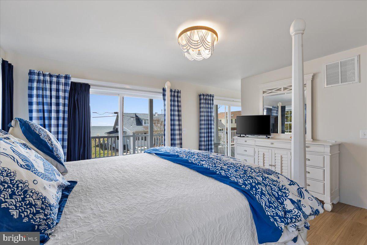 2818 Beach Drive Huntingtown, MD 20639 - Photo 24 of 74 a bedroom with a large bed and a flat screen tv