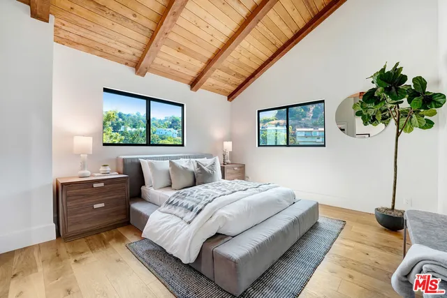 a bedroom with a bed and a wooden floor