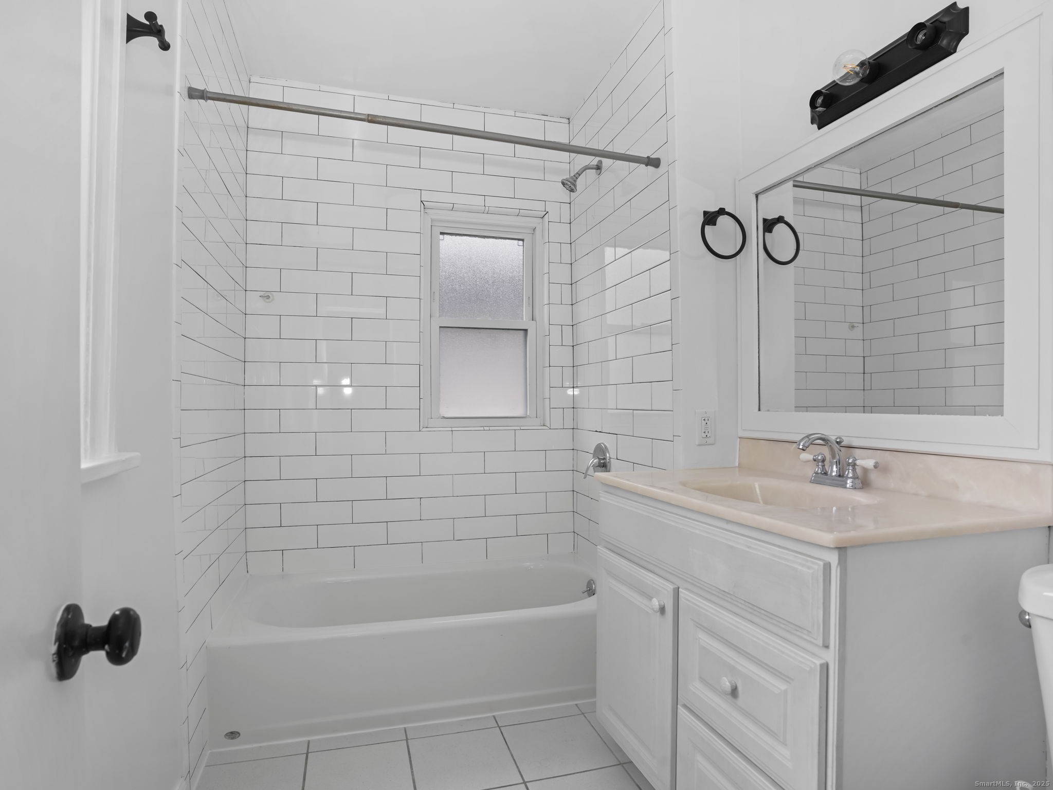 90 Amsterdam Avenue, Unit 1 Bridgeport, CT 06606 - Photo 11 of 14 a bathroom with a sink a toilet a mirror and shower