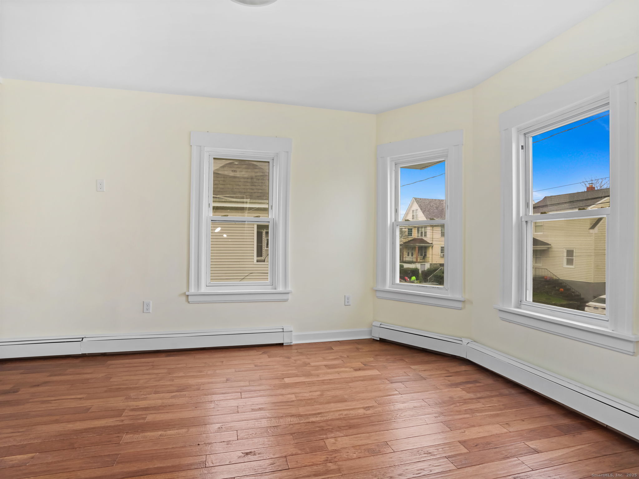90 Amsterdam Avenue, Unit 1 Bridgeport, CT 06606 - Photo 6 of 14 a view of an empty room with wooden floor and a window