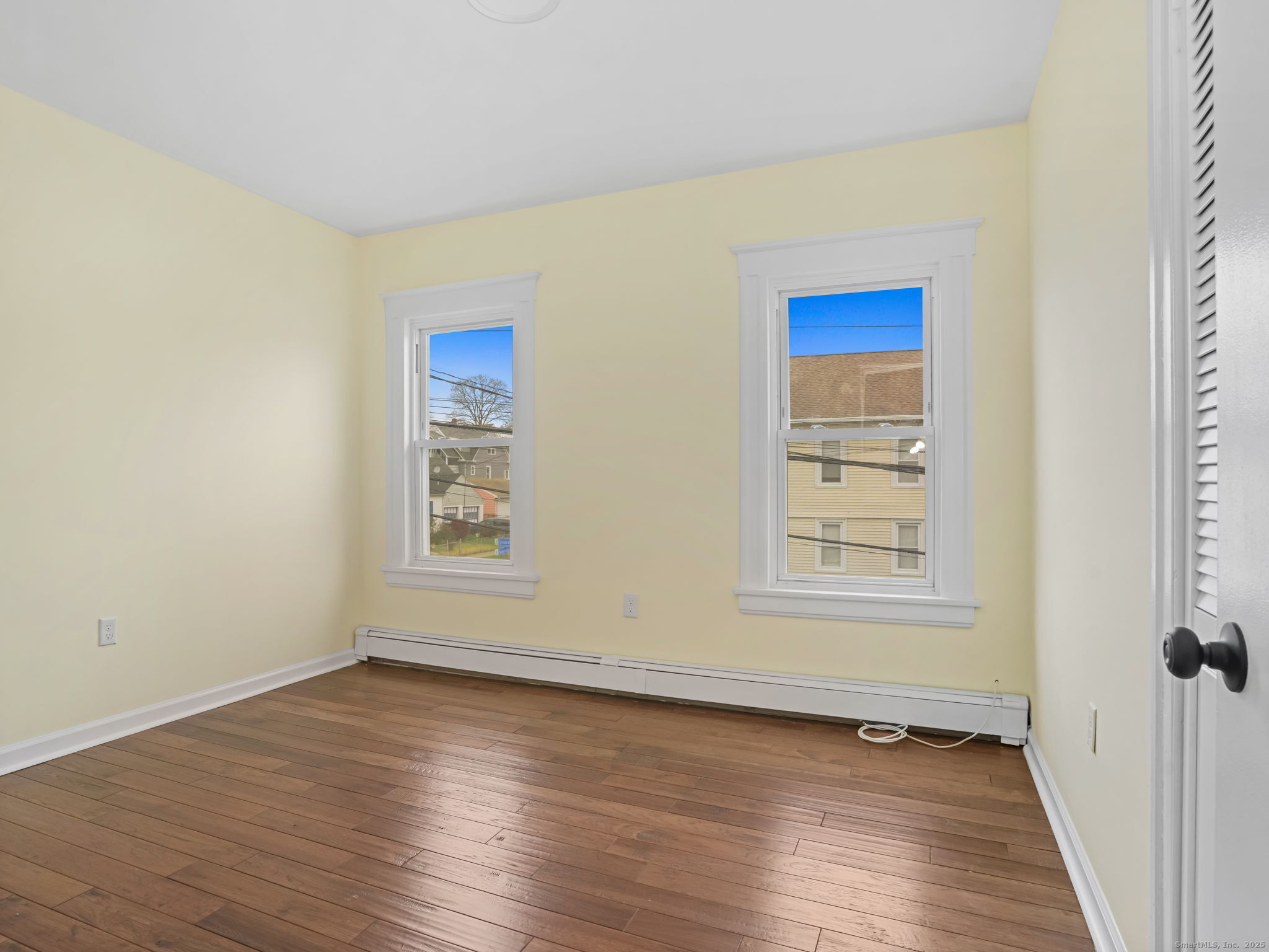 90 Amsterdam Avenue, Unit 1 Bridgeport, CT 06606 - Photo 7 of 14 an empty room with wooden floor and windows