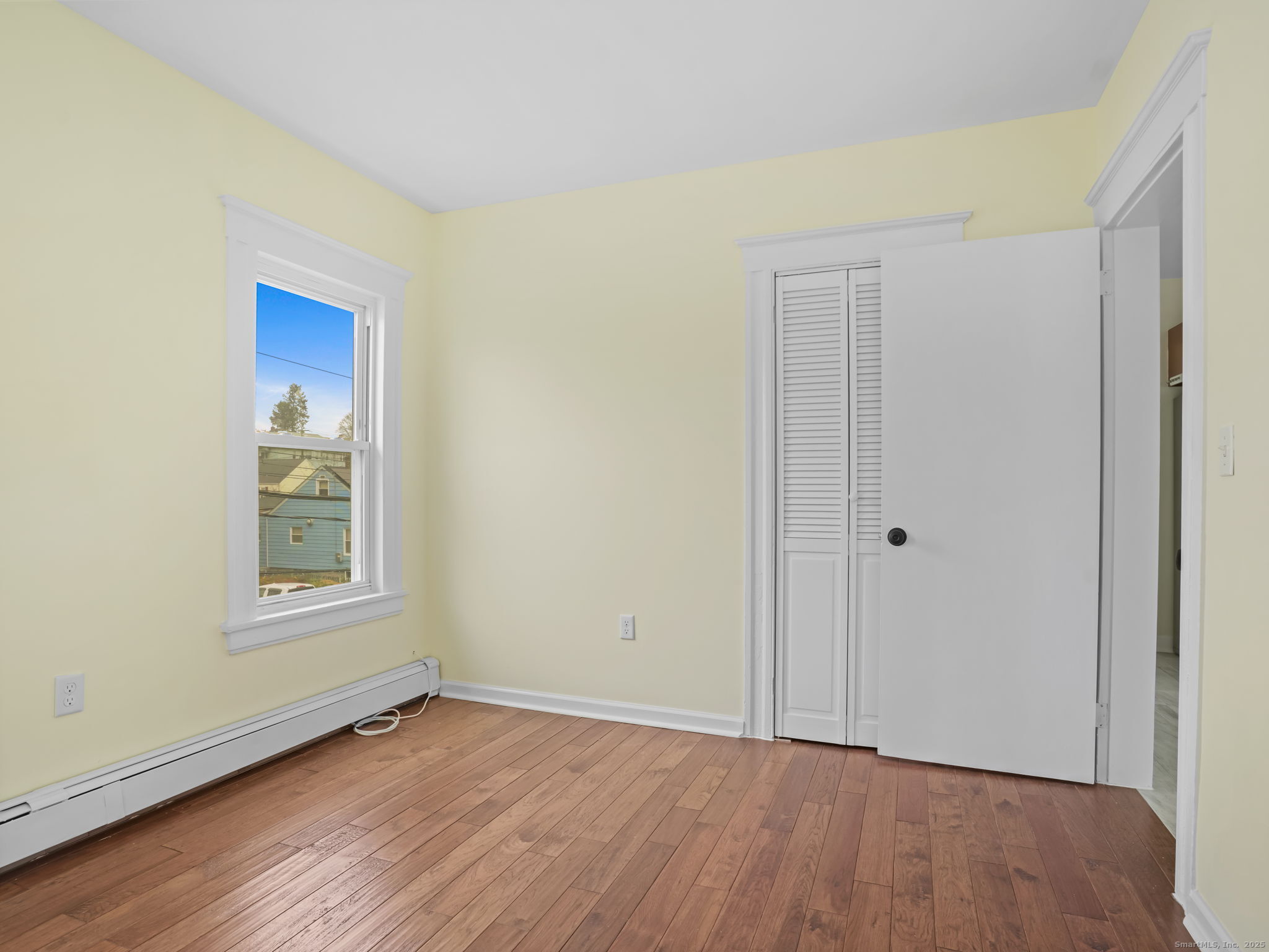 90 Amsterdam Avenue, Unit 1 Bridgeport, CT 06606 - Photo 8 of 14 a view of an empty room with wooden floor and a window