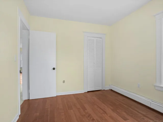 a view of an empty room with wooden floor