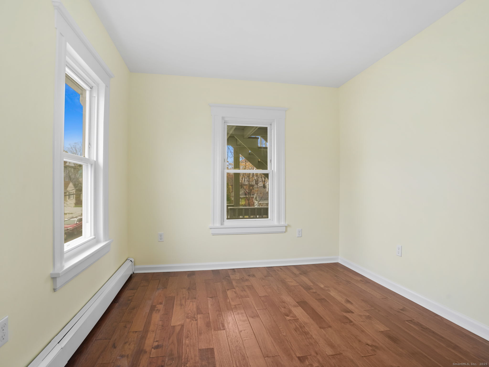 90 Amsterdam Avenue, Unit 1 Bridgeport, CT 06606 - Photo 10 of 14 an empty room with wooden floor and windows