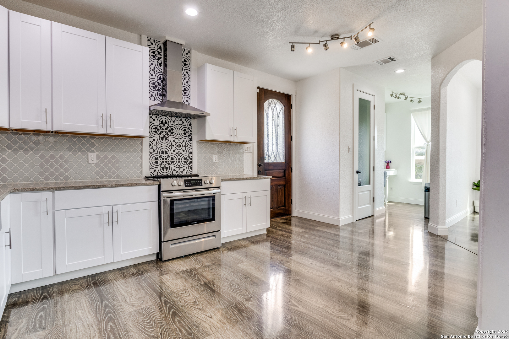 1071 Hidden Valley Drive Spring Branch, TX 78070 - Photo 11 of 30 a kitchen with stainless steel appliances granite countertop a stove a sink and a refrigerator with white cabinets