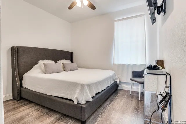 a bed sitting in a bedroom next to a window and a chair