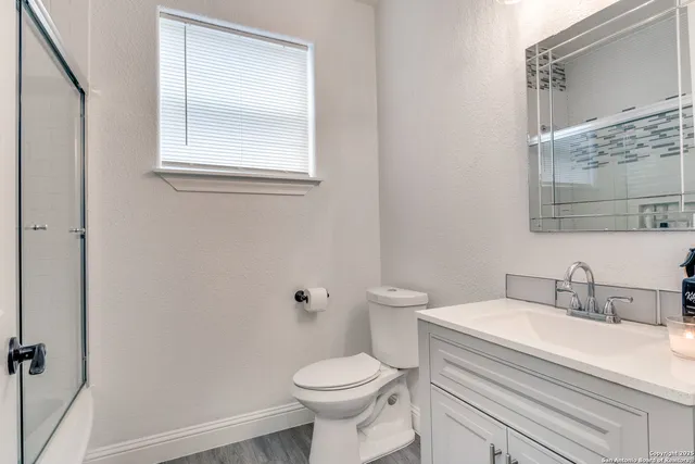 a bathroom with a sink toilet and a mirror