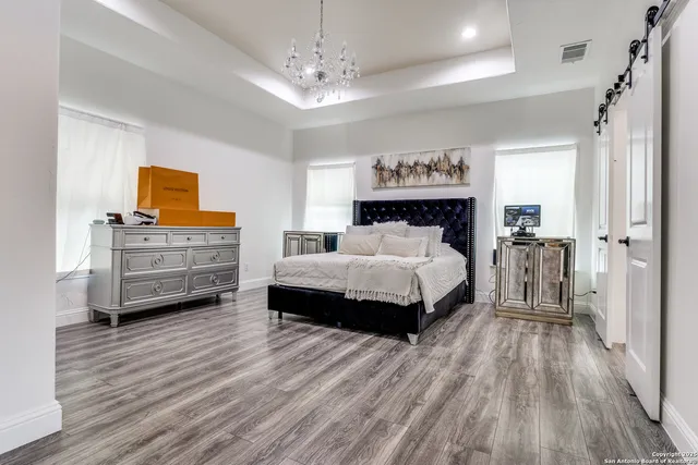 a bedroom with a bed and a wooden floor