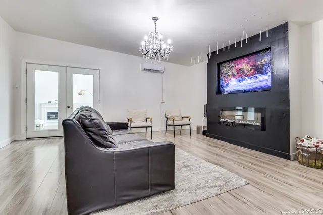 a living room with furniture a chandelier and a flat screen tv