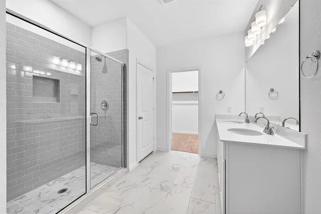 a bathroom with a shower sink and mirror