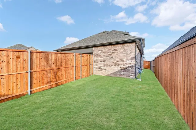 a view of a backyard with wooden fence
