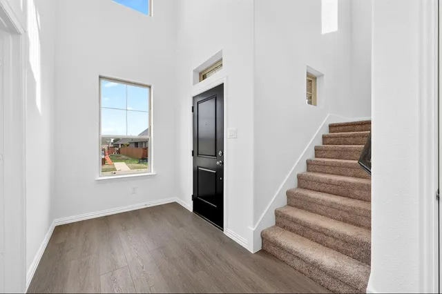 a view of an entryway with wooden floor and door