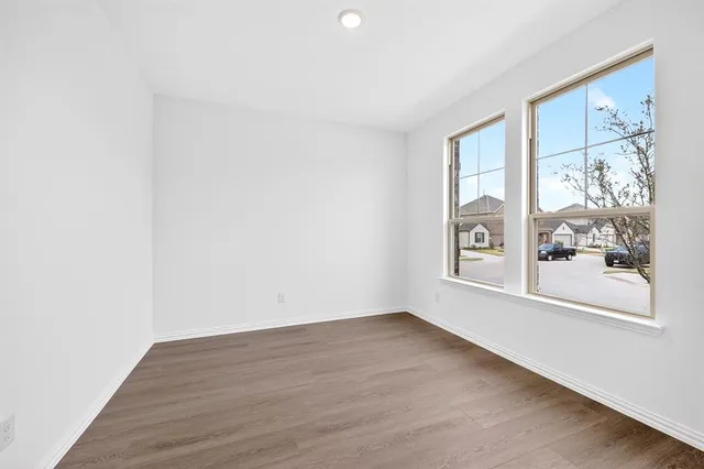 a view of a big room with wooden floor and a window
