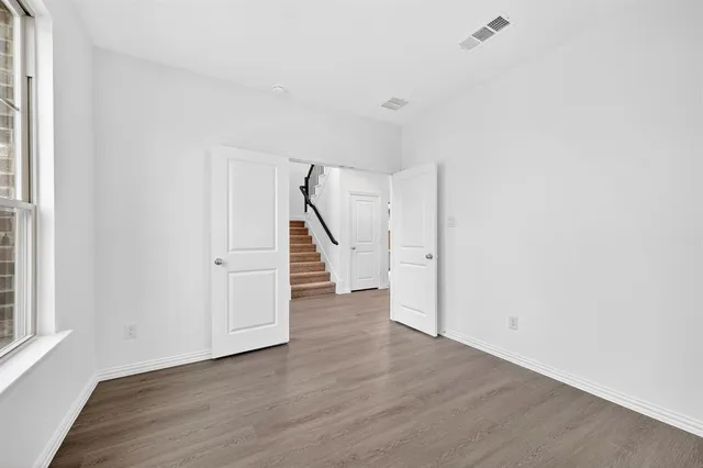 an empty room with wooden floor and entryway
