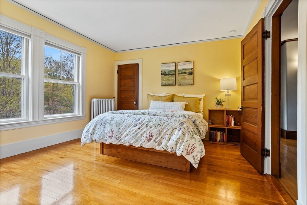 256 Great Road Stow, MA 01775 - Photo 26 of 42 a bedroom with a bed and wooden floor