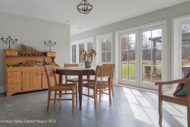 a dining room with furniture and large windows