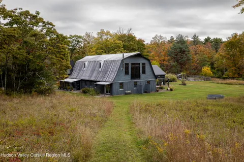 a view of a big house with a big yard and large trees