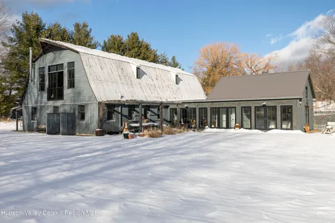 a view of a big house with a big yard and large trees