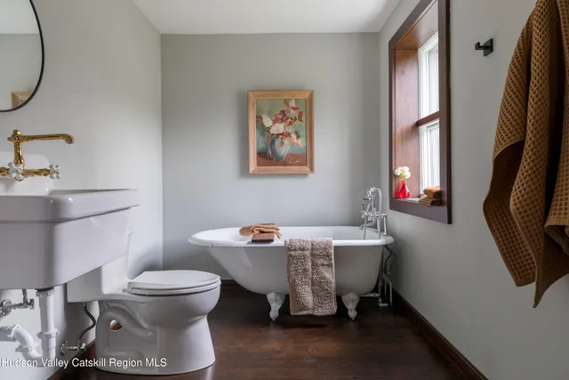 a bathroom with a sink toilet and a mirror