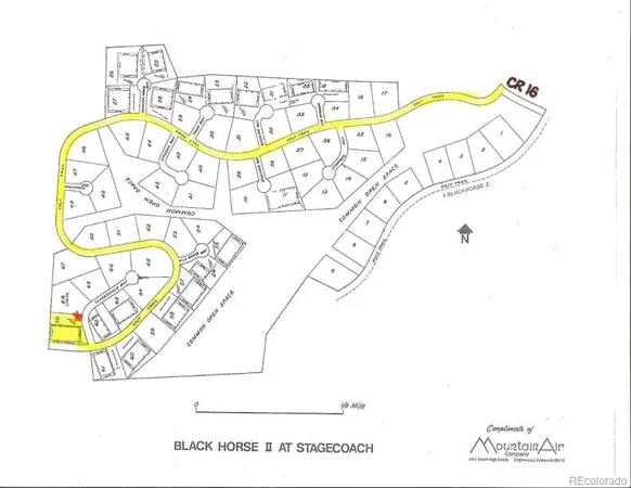 a picture of a white wall with a white comforter and a painting on the wall