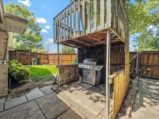 a view of backyard with wooden fence and large trees