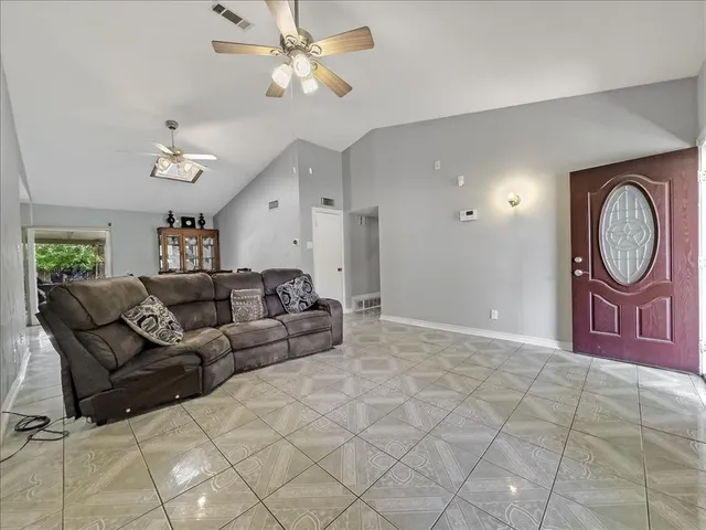 a living room with furniture a large window and a chandelier