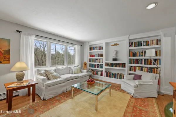 a living room with furniture and a book shelf