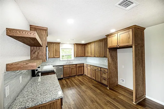 a kitchen with stainless steel appliances granite countertop a sink stove and refrigerator