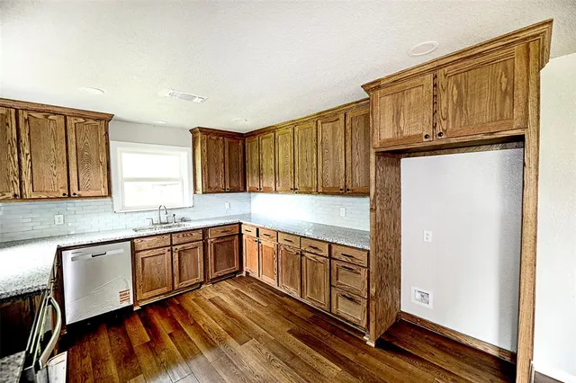 a kitchen with stainless steel appliances granite countertop a refrigerator and wooden cabinets