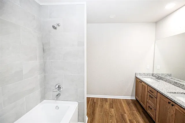 a bathroom with a granite countertop sink a toilet a vanity and bathtub