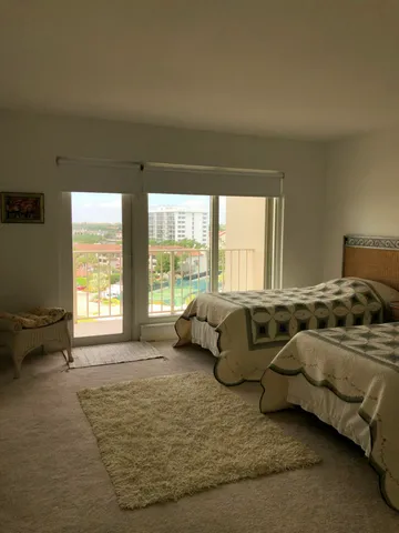 a bedroom with two beds and large window
