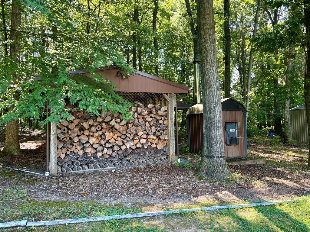 1222 Spring Road Andreas, PA 18211 - Photo 29 of 38 A well-maintained woodshed with a generous supply of firewood sits nestled among mature trees.