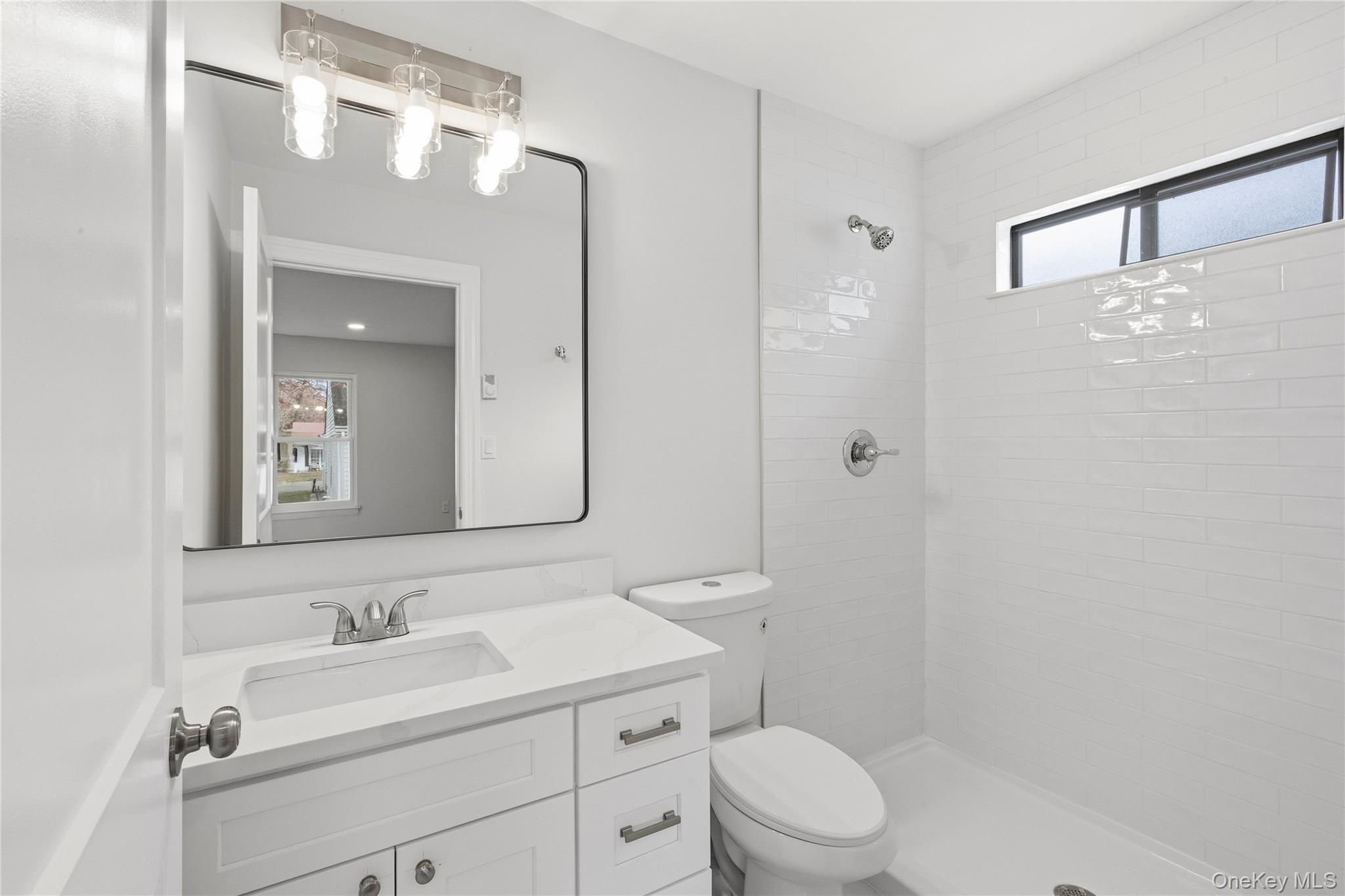 145 Edinburgh Drive Ridge, NY 11961 - Photo 11 of 13 a bathroom with a toilet a sink a mirror a vanity and shower