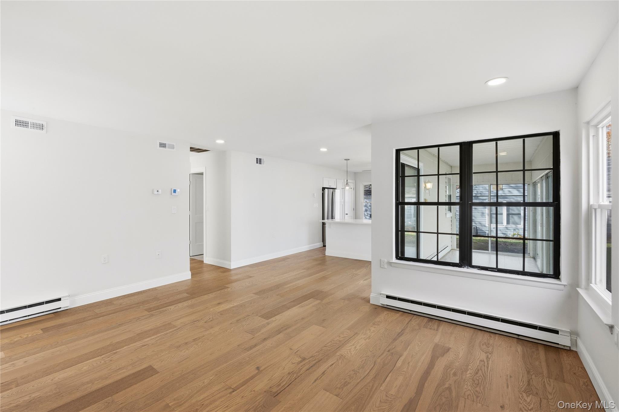 145 Edinburgh Drive Ridge, NY 11961 - Photo 3 of 13 wooden floor in an empty room with a window