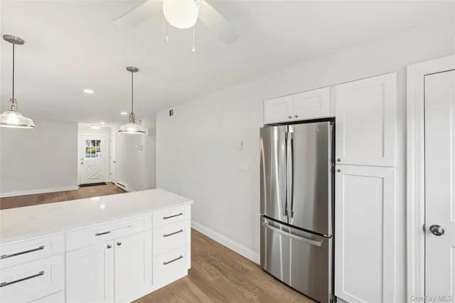 a kitchen with kitchen island a counter top space wooden floor and appliances