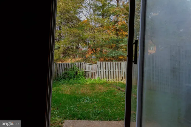 a view of backyard with barbeque grill and wooden fence