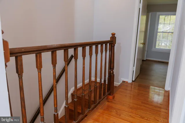 a view of a hallway with wooden floor and stairs
