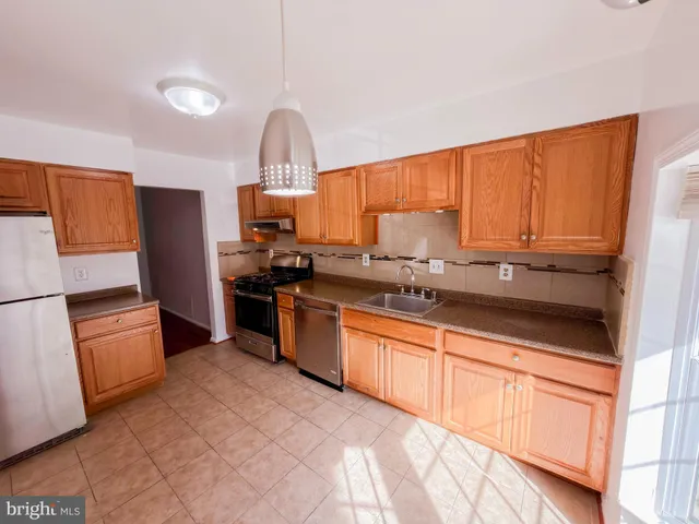 a kitchen with granite countertop a refrigerator stove top oven and sink