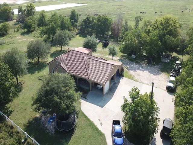 an aerial view of a house with a yard basket ball court and outdoor seating