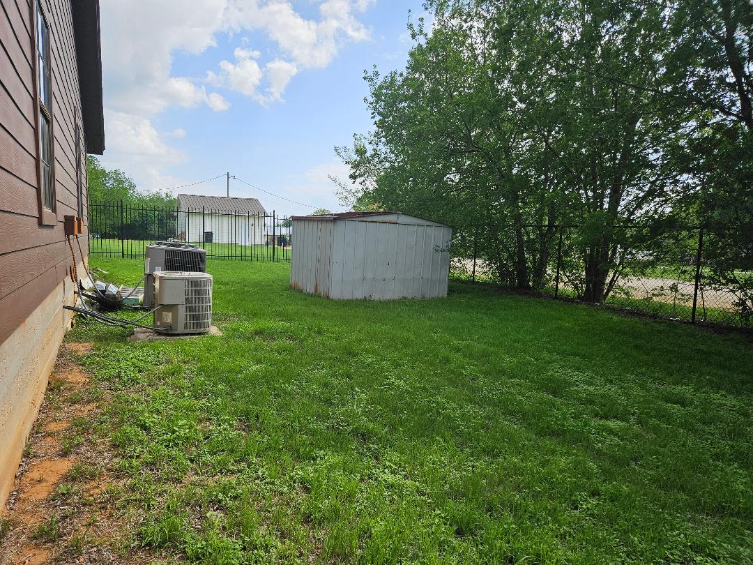 16 North Ave A, Unit B Elgin, TX 78621 - Photo 14 of 17 Back yard. The storage building is on side A and belongs to that tenant