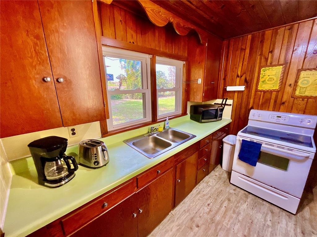 106 Sunny Side Beach Road Hawthorne, FL 32640 - Photo 13 of 54 a kitchen with stainless steel appliances a sink a stove and a wooden floor